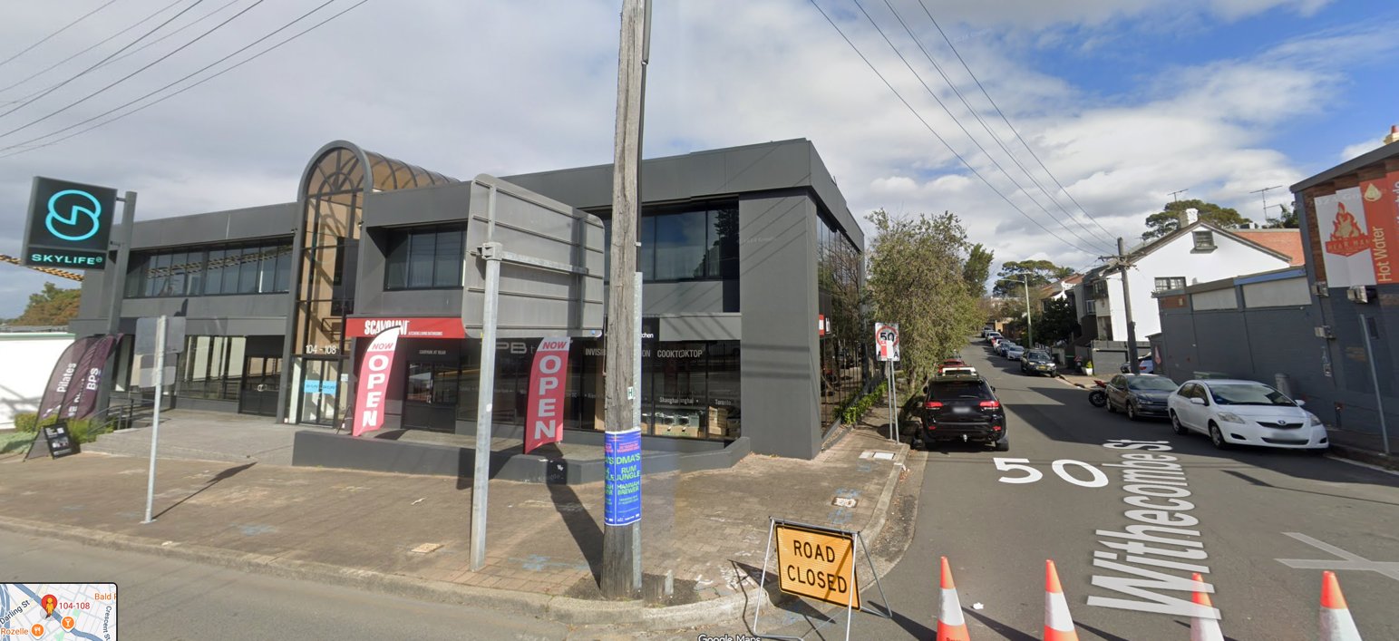 The existing two-storey Skylife commercial building at 104–108 Victoria Road, seen from the corner of Withecombe Street